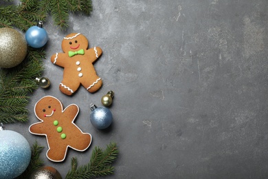 Photo of Flat lay composition with gingerbread people on grey table. Space for text
