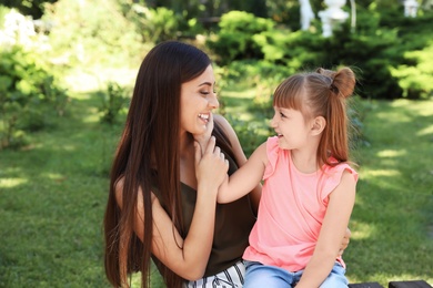 Photo of Mother with her cute child on bench in park. Happy family