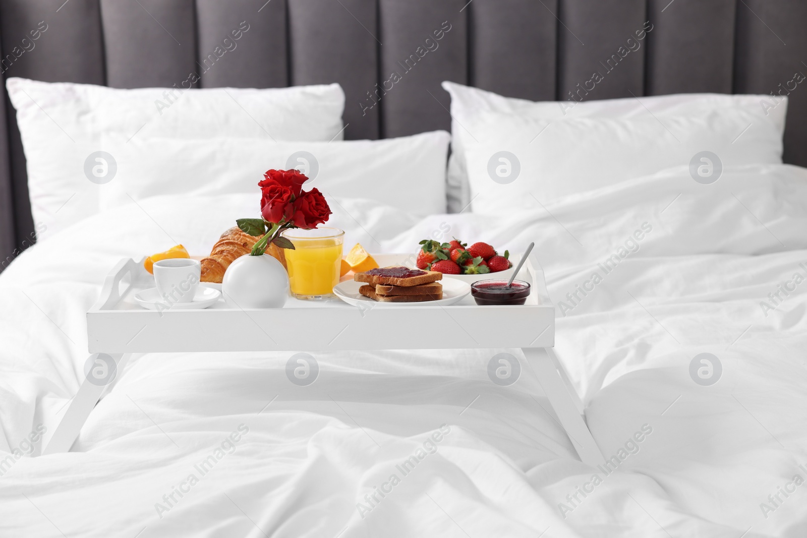 White tray with delicious breakfast on bed Photo of White tray with delicious breakfast on bed