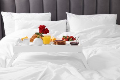 Photo of White tray with delicious breakfast on bed