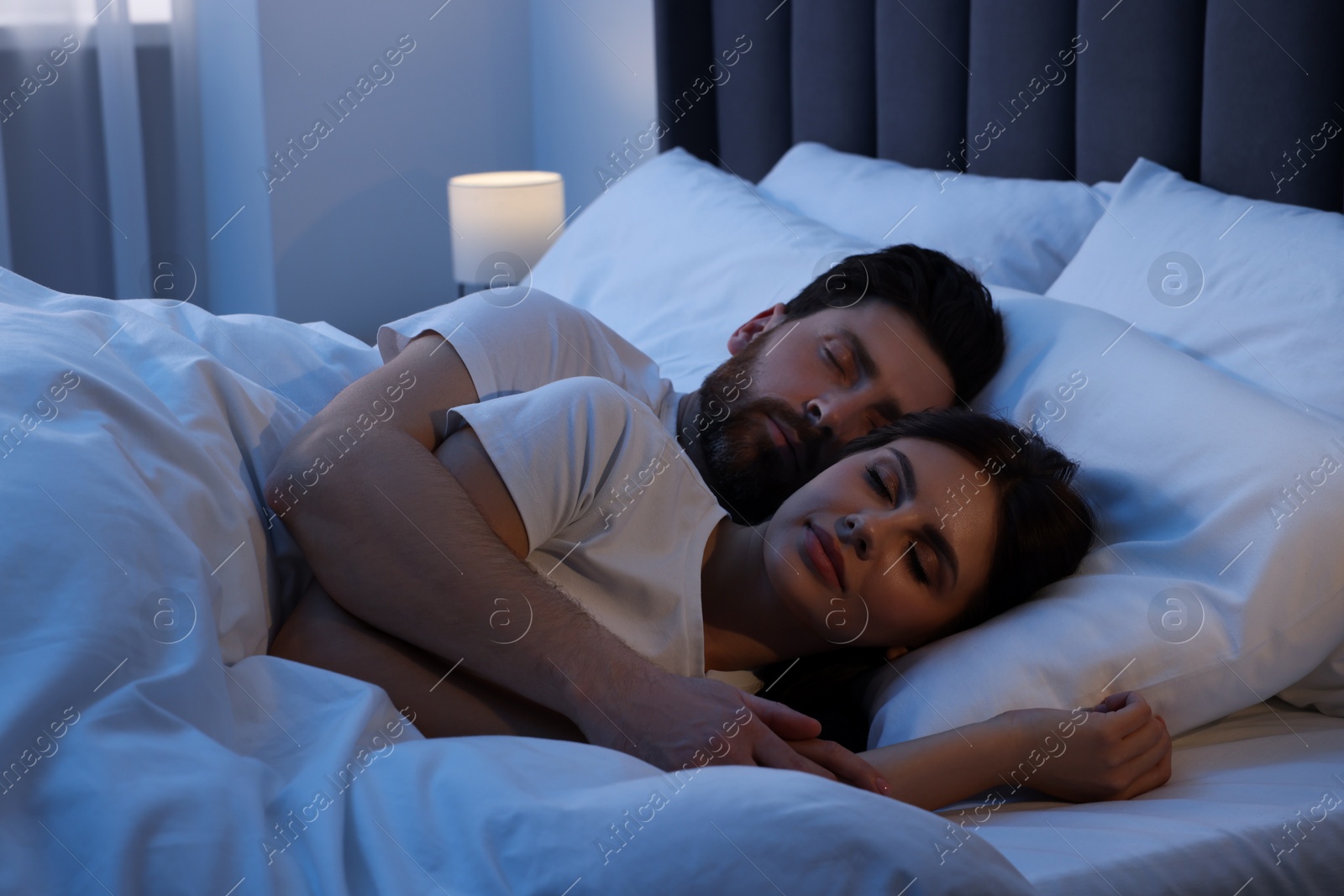 Photo of Lovely couple sleeping together in bed at night