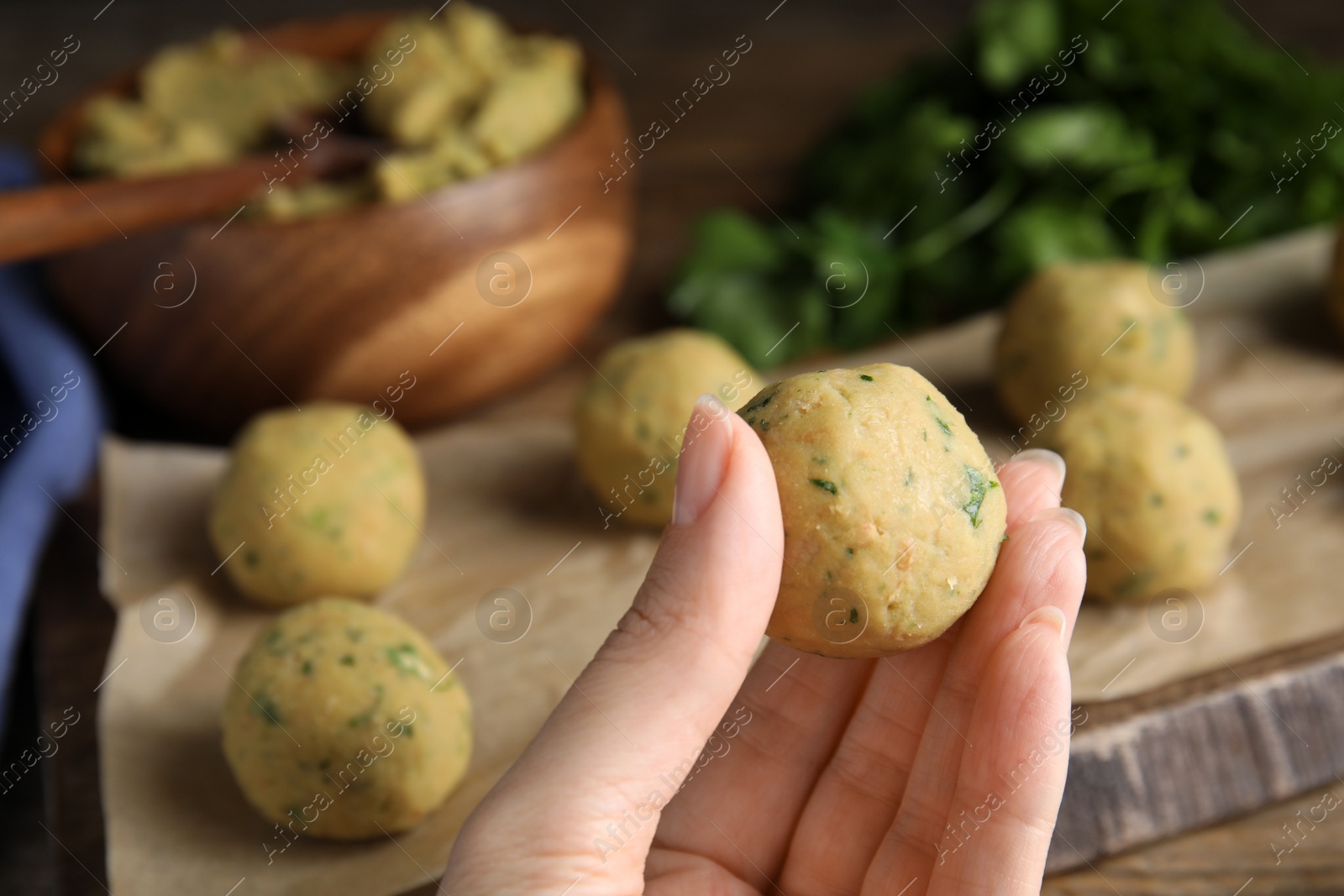 Photo of Woman with raw falafel ball at table, closeup. Space for text