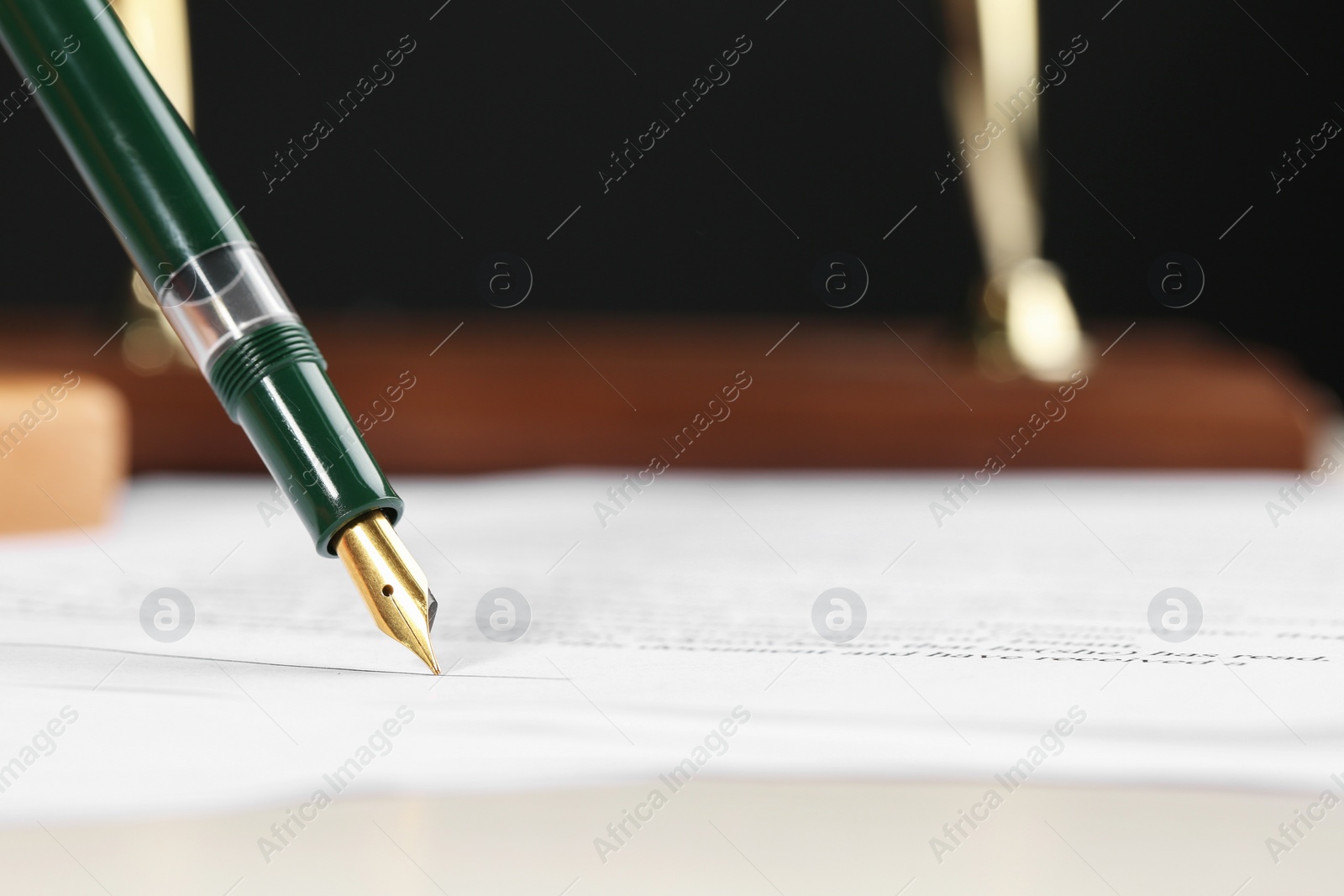 Photo of Signing notary document with fountain pen, closeup