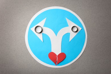 Photo of Divorce concept. Paper heart, arrows and rings on light grey background, flat lay