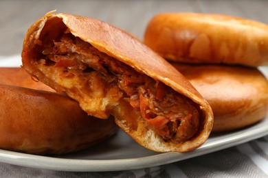 Photo of Delicious baked patties with cabbage on kitchen towel, closeup