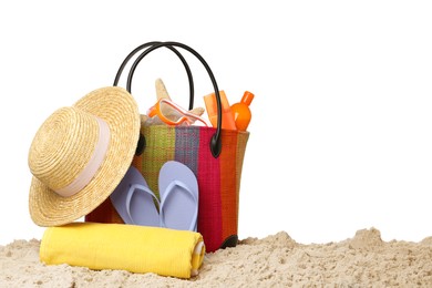 Stylish bag with beach accessories on sand against white background