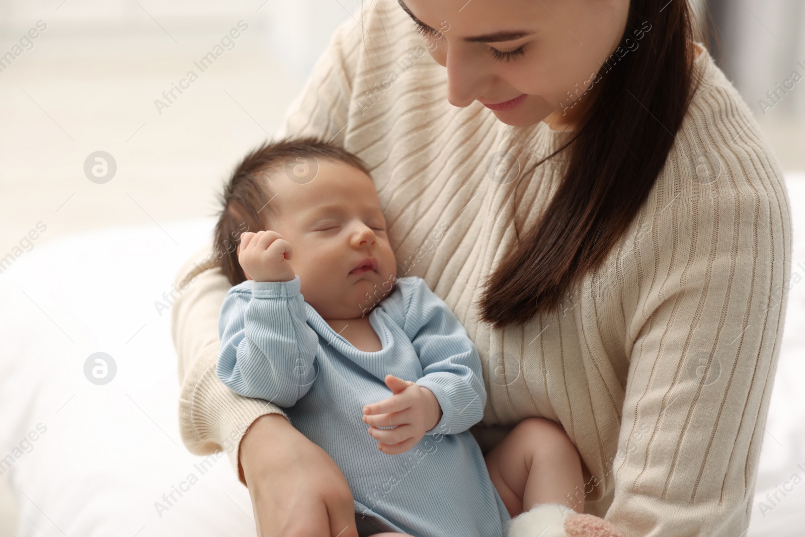 Photo of Mother with her sleeping newborn baby on light background, closeup