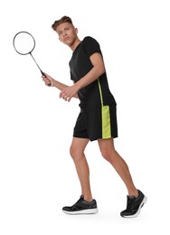 Young man playing badminton with racket on white background