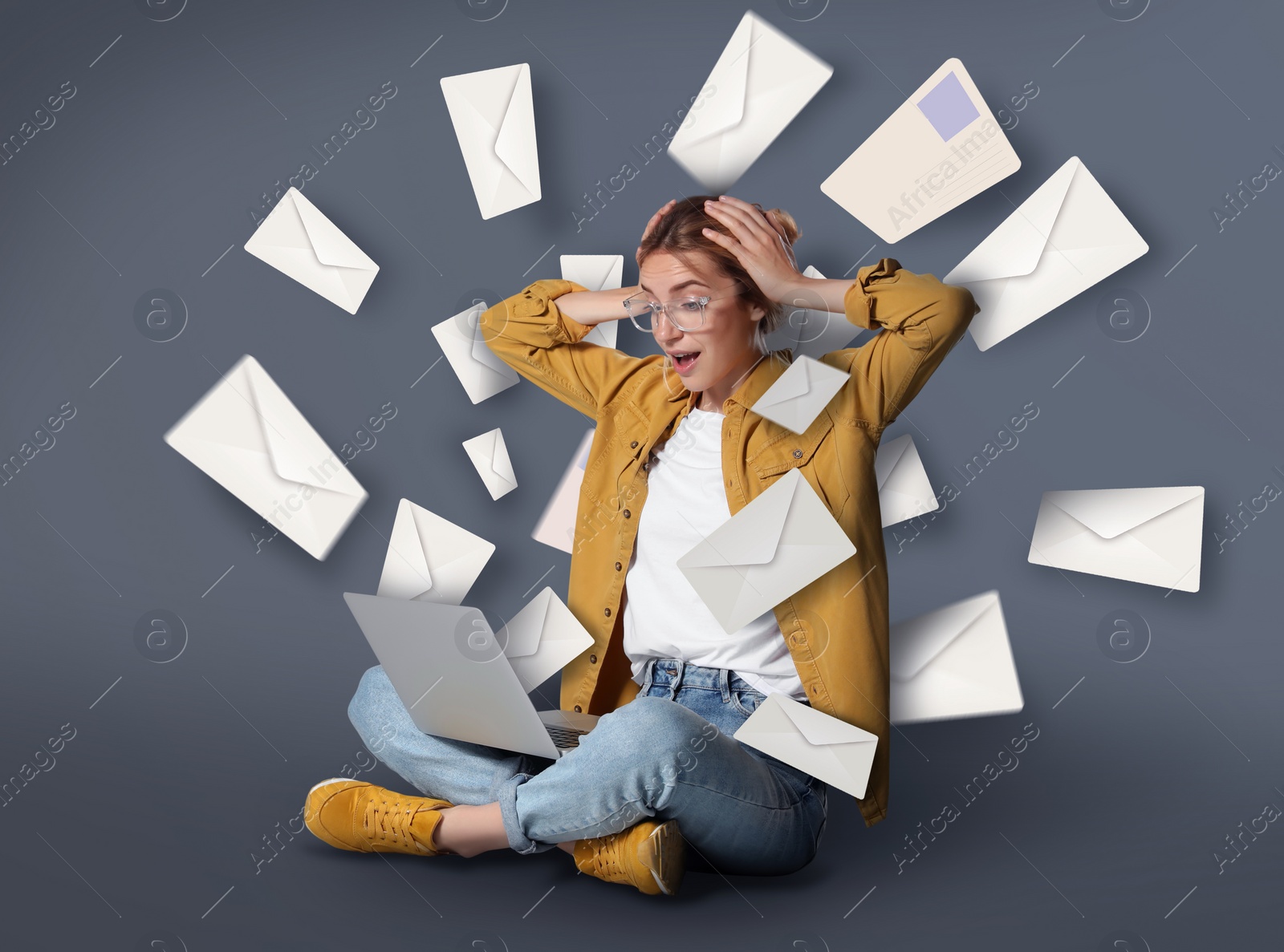 Image of Email spam. Emotional young woman with laptop and many letters on grey background