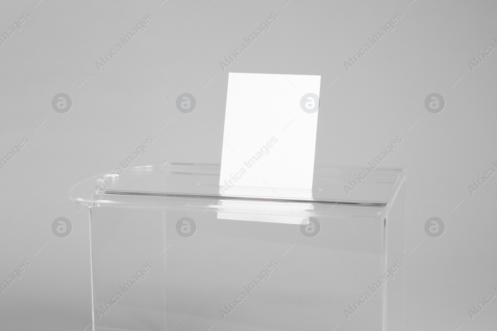 Photo of Ballot box with vote on light grey background, closeup. Election time