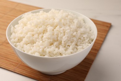 Photo of Bowl with delicious rice on white table, closeup