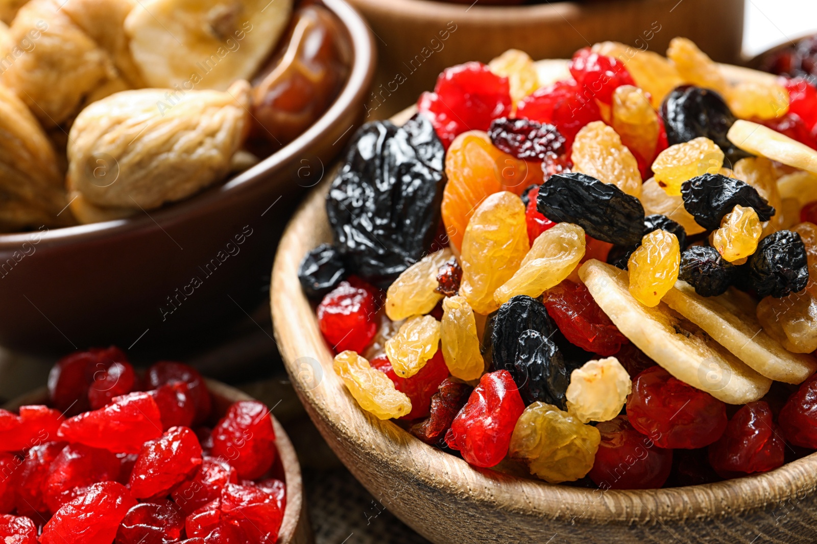 Photo of Bowls with different dried fruits on table, closeup. Healthy lifestyle