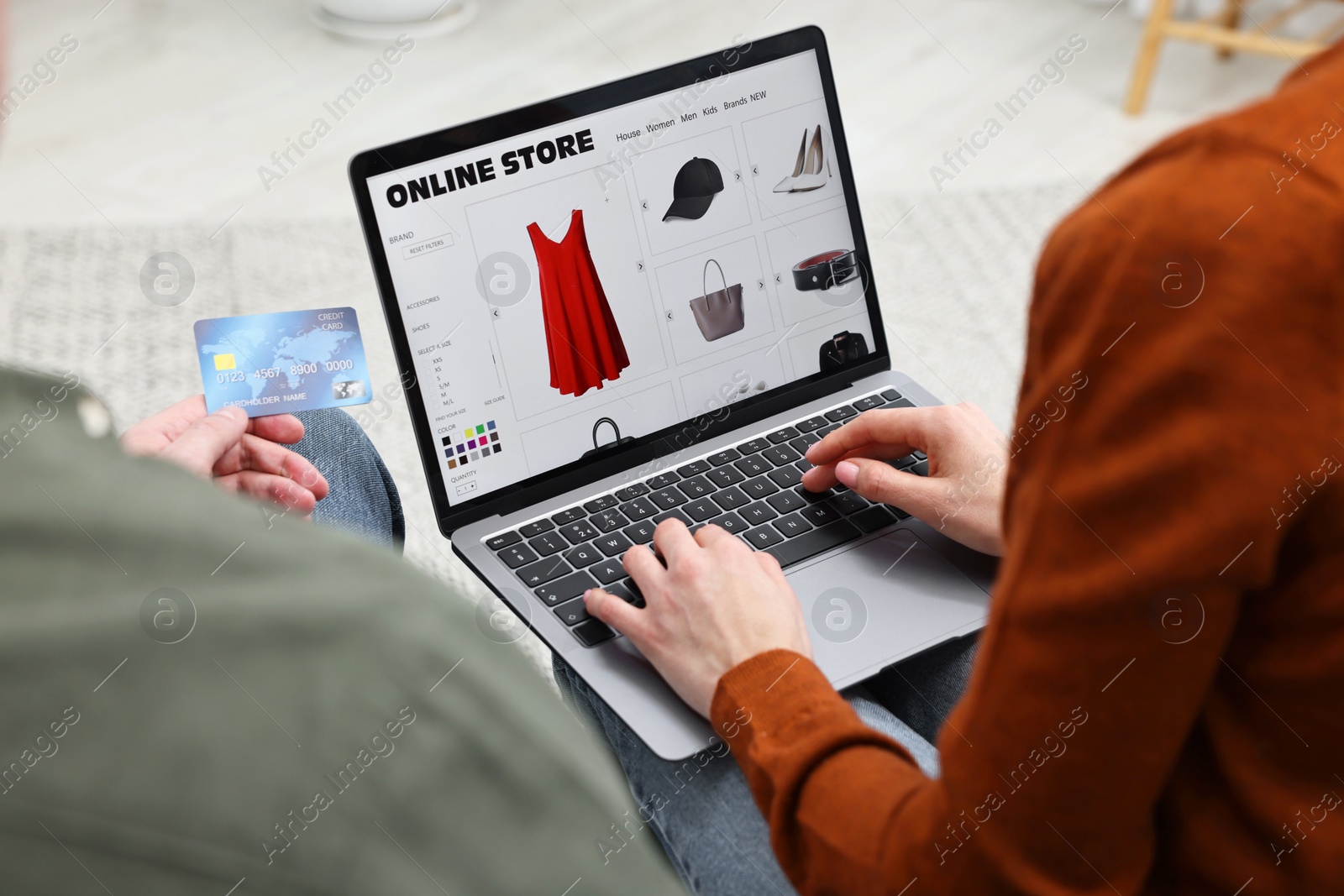 Photo of Couple with credit card using laptop for shopping online indoors, closeup