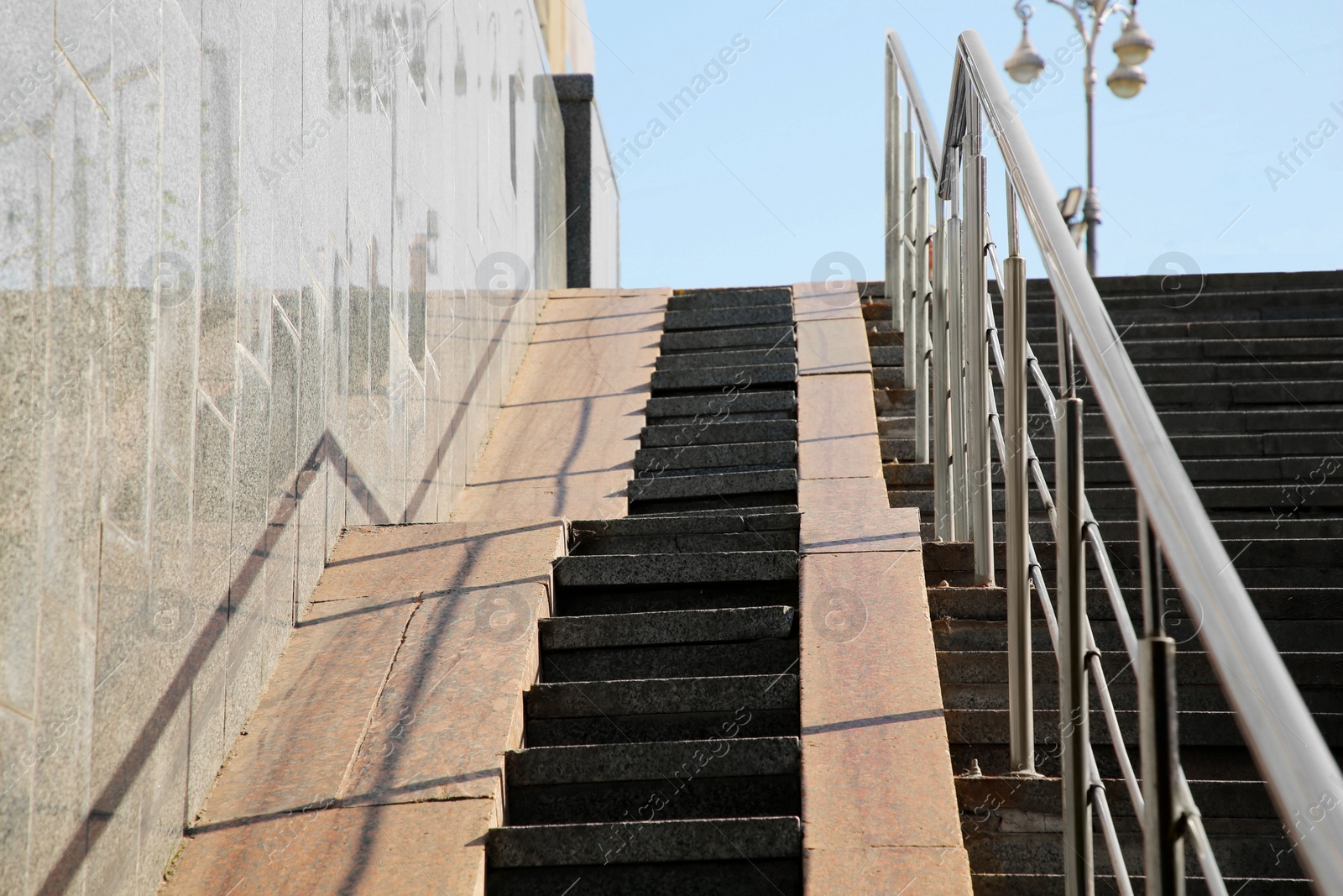 Photo of Staircase and ramp with metal handrail near building outdoors