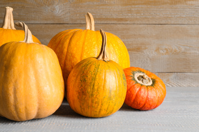 Photo of Many different ripe pumpkins on wooden table