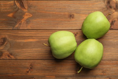 Photo of Fresh green apples on wooden table, flat lay. Space for text