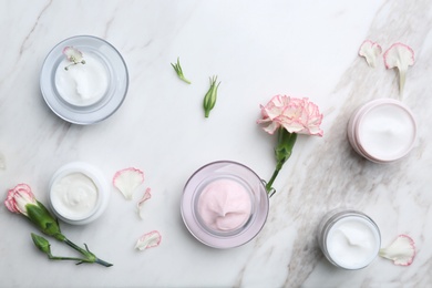 Photo of Jars with different body cream on marble background