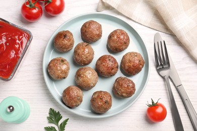 Tasty cooked meatballs served on white wooden table, flat lay