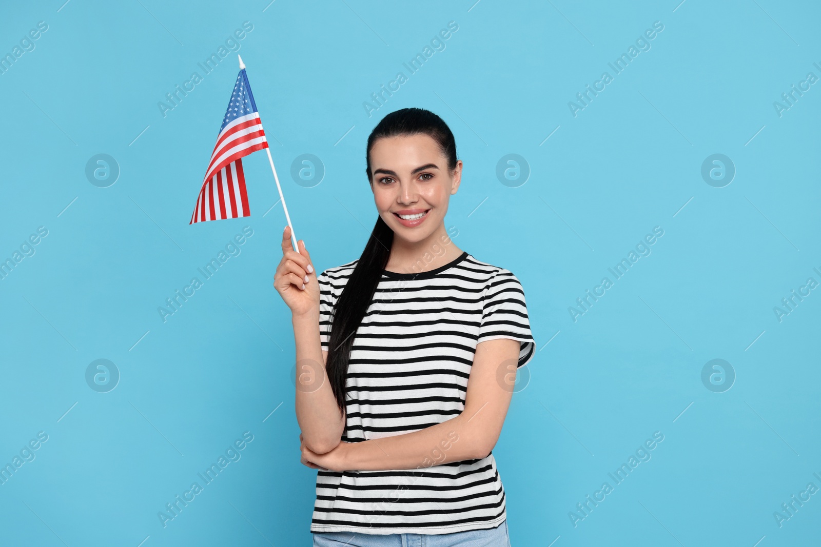 Photo of 4th of July - Independence Day of USA. Happy woman with American flag on light blue background