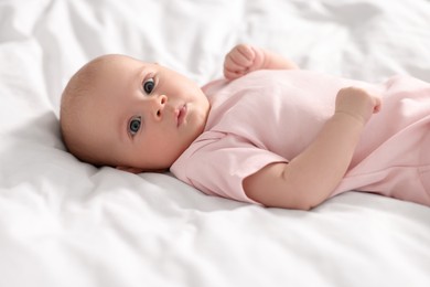 Cute little baby lying on white sheets