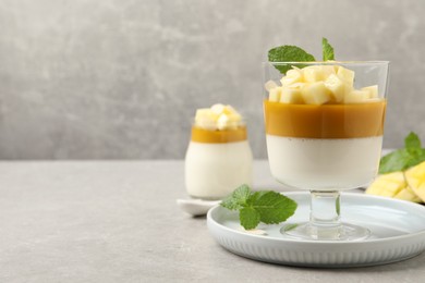 Photo of Delicious panna cotta with mango on grey table. Space for text