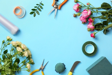 Florist equipment with flowers on color background, top view