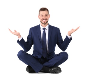 Businessman sitting in lotus position and showing balance gesture on white background