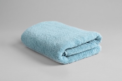 Photo of Fresh fluffy folded towel on grey background