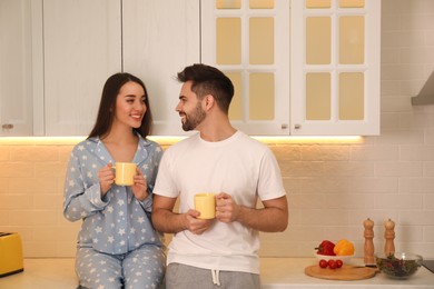 Happy couple in pajamas having breakfast at home