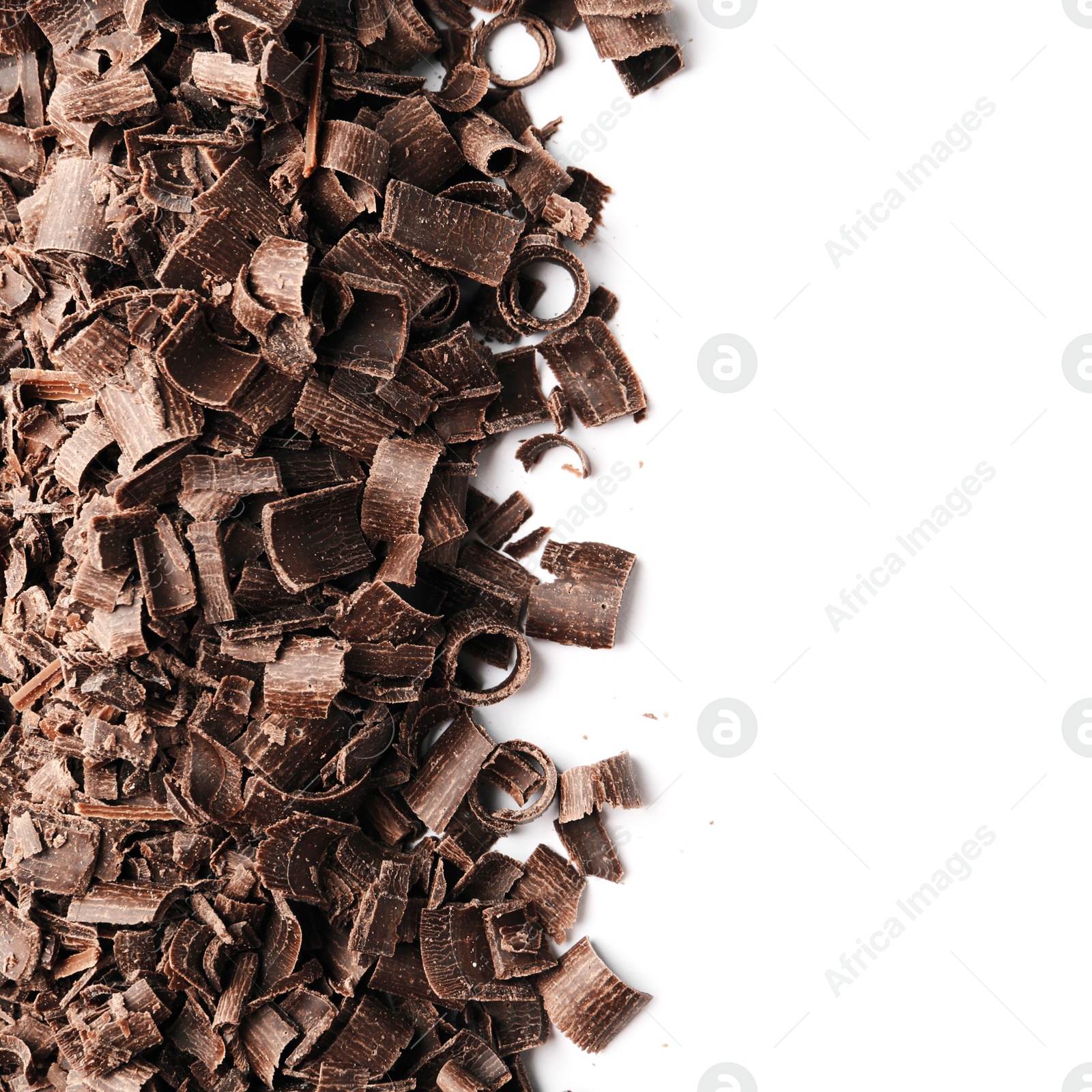 Photo of Curls of tasty chocolate on white background, top view