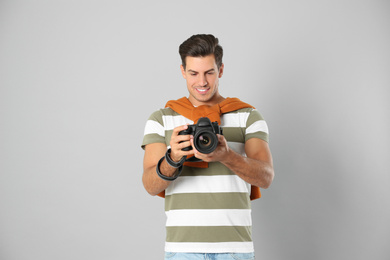 Photo of Professional photographer working on light grey background in studio