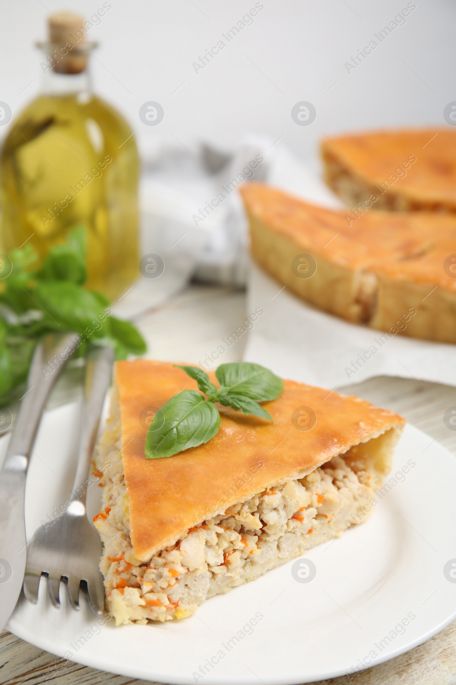 Photo of Slice of delicious meat pie with basil on table, space for text