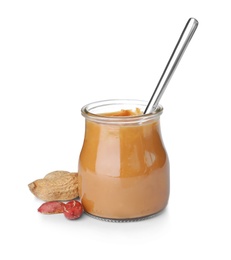 Jar and spoon with creamy peanut butter on white background