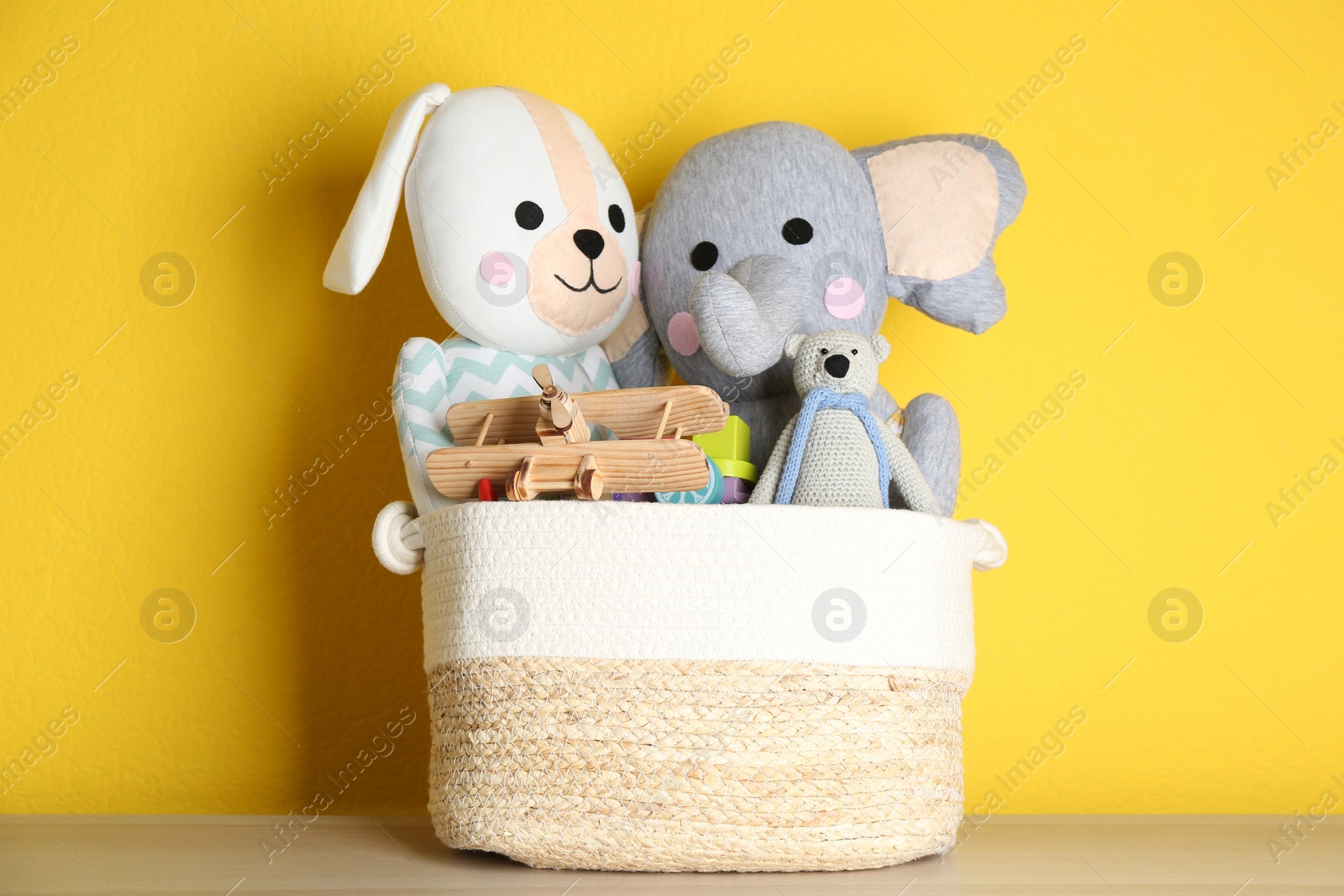 Photo of Basket with different toys on wooden table