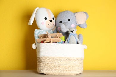 Basket with different toys on wooden table