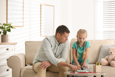 Photo of Child psychotherapist working with little girl in office