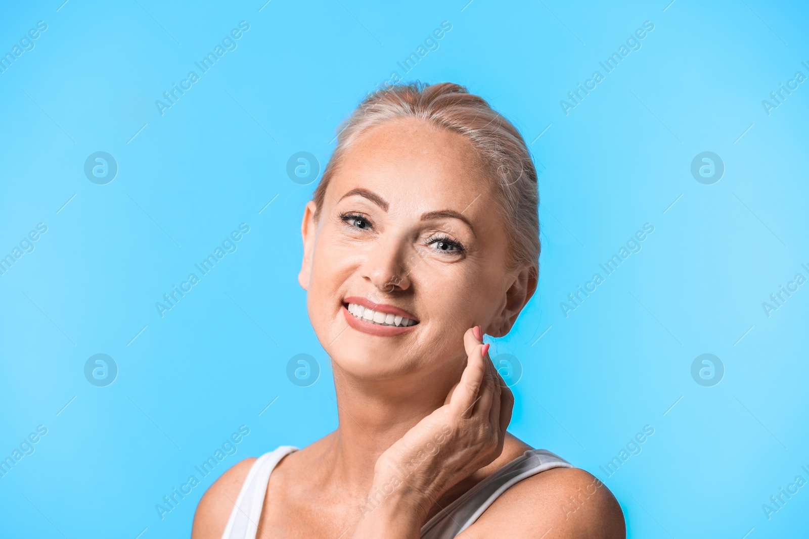 Photo of Portrait of beautiful mature woman with perfect skin on light blue background