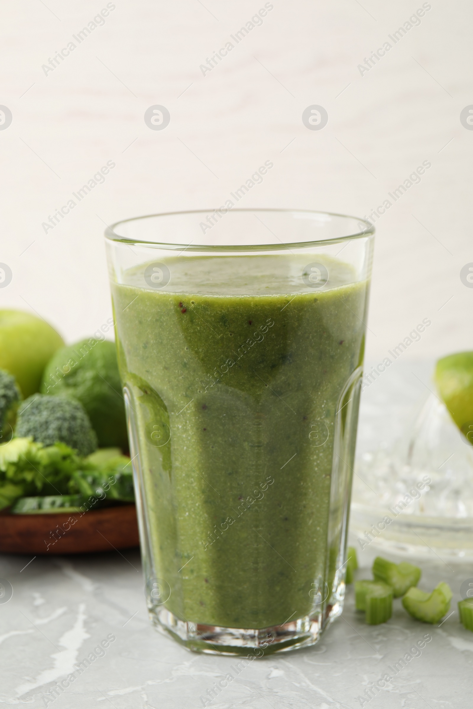 Photo of Delicious fresh green juice on grey marble table