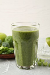 Photo of Delicious fresh green juice on grey marble table