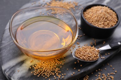 Photo of Bowl of natural oil and mustard seeds on table, closeup. Space for text