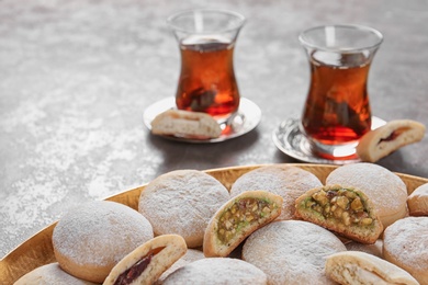Photo of Traditional cookies for Islamic holidays and tea on table. Eid Mubarak