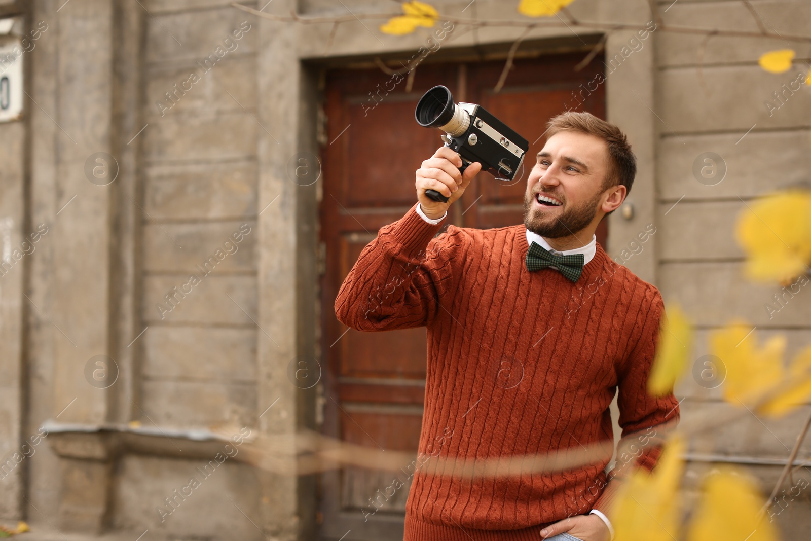 Photo of Young man with vintage video camera outdoors