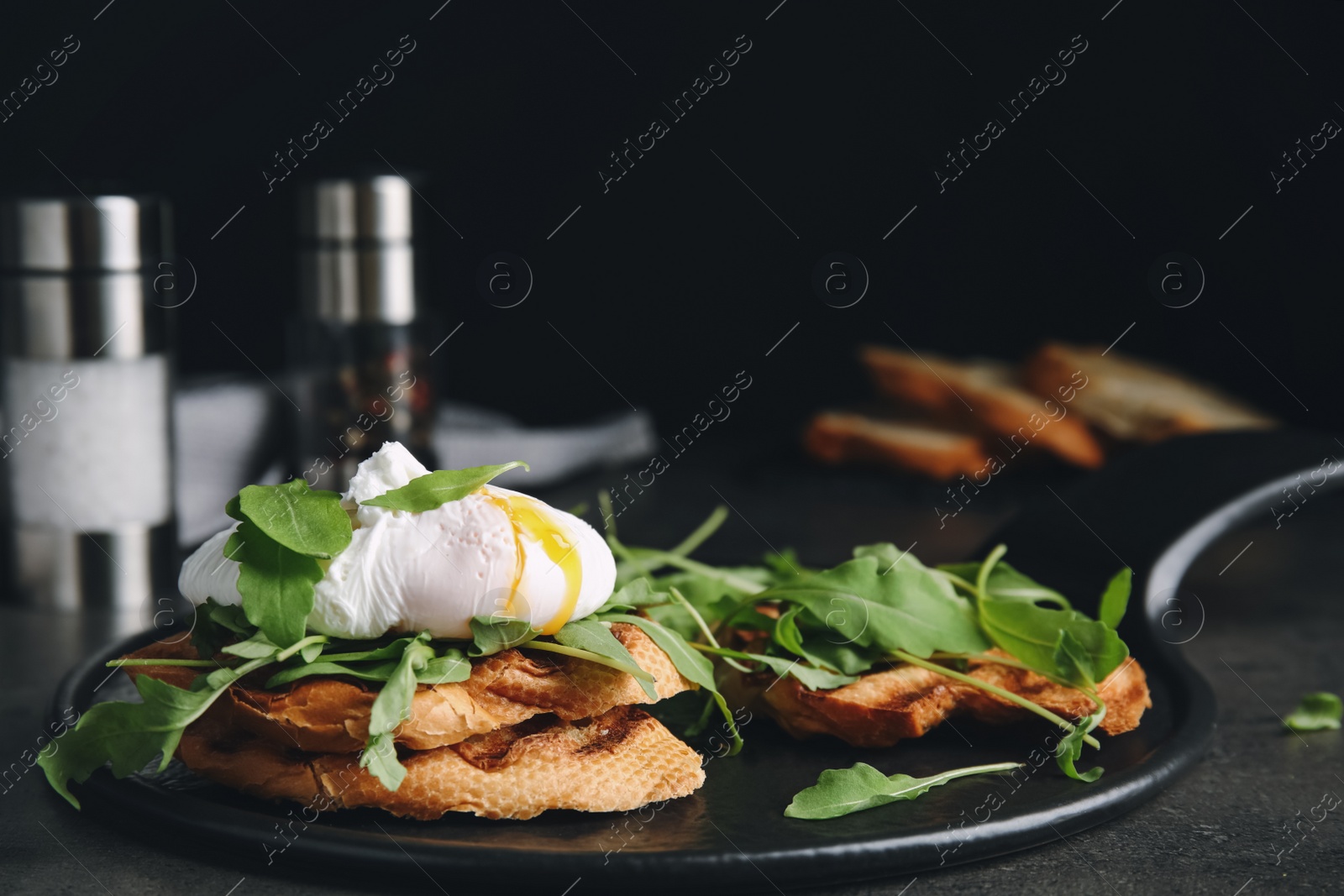 Photo of Delicious sandwich with arugula and egg on grey table