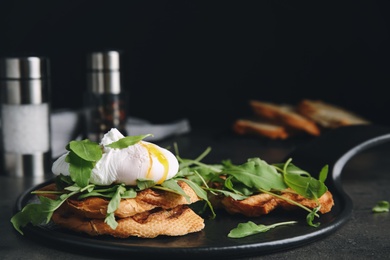 Delicious sandwich with arugula and egg on grey table