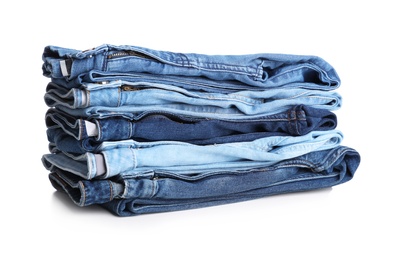 Photo of Stack of stylish jeans on white background