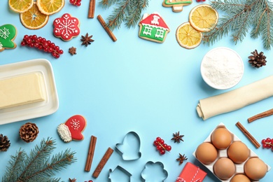 Photo of Frame of Christmas cookies, decor and flour on light blue background, flat lay. Space for text