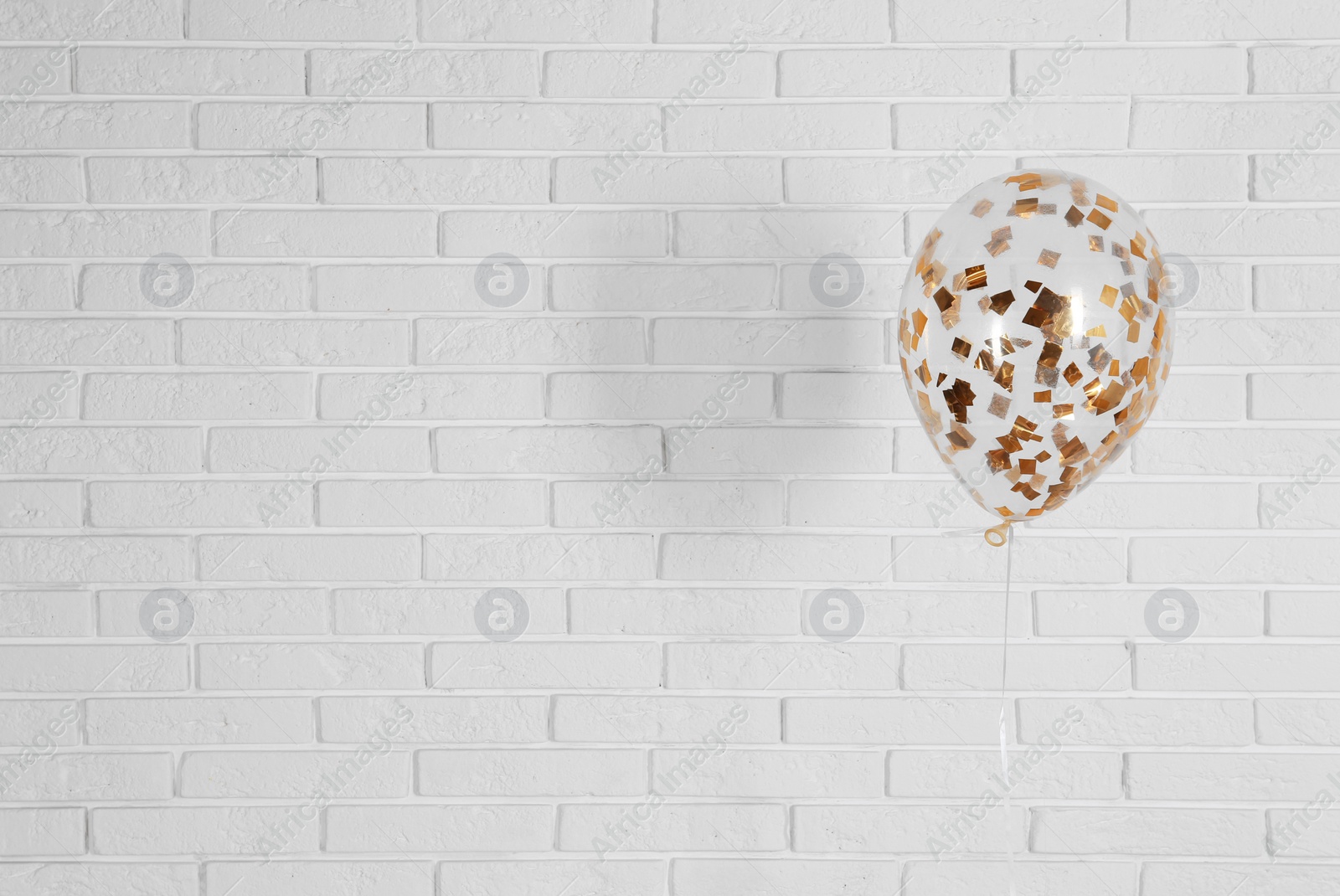 Photo of Bright balloon near brick wall, space for text. Party time