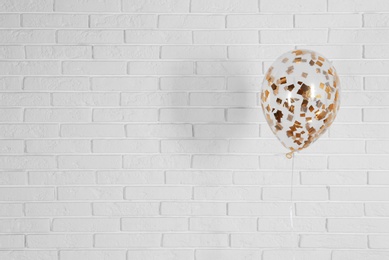 Photo of Bright balloon near brick wall, space for text. Party time