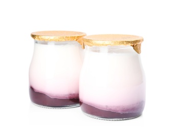 Photo of Glass jars of tasty fruit yogurt on white background