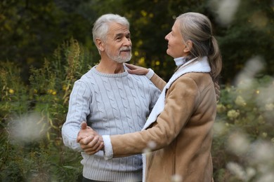 Affectionate senior couple dancing together outdoors. Romantic date